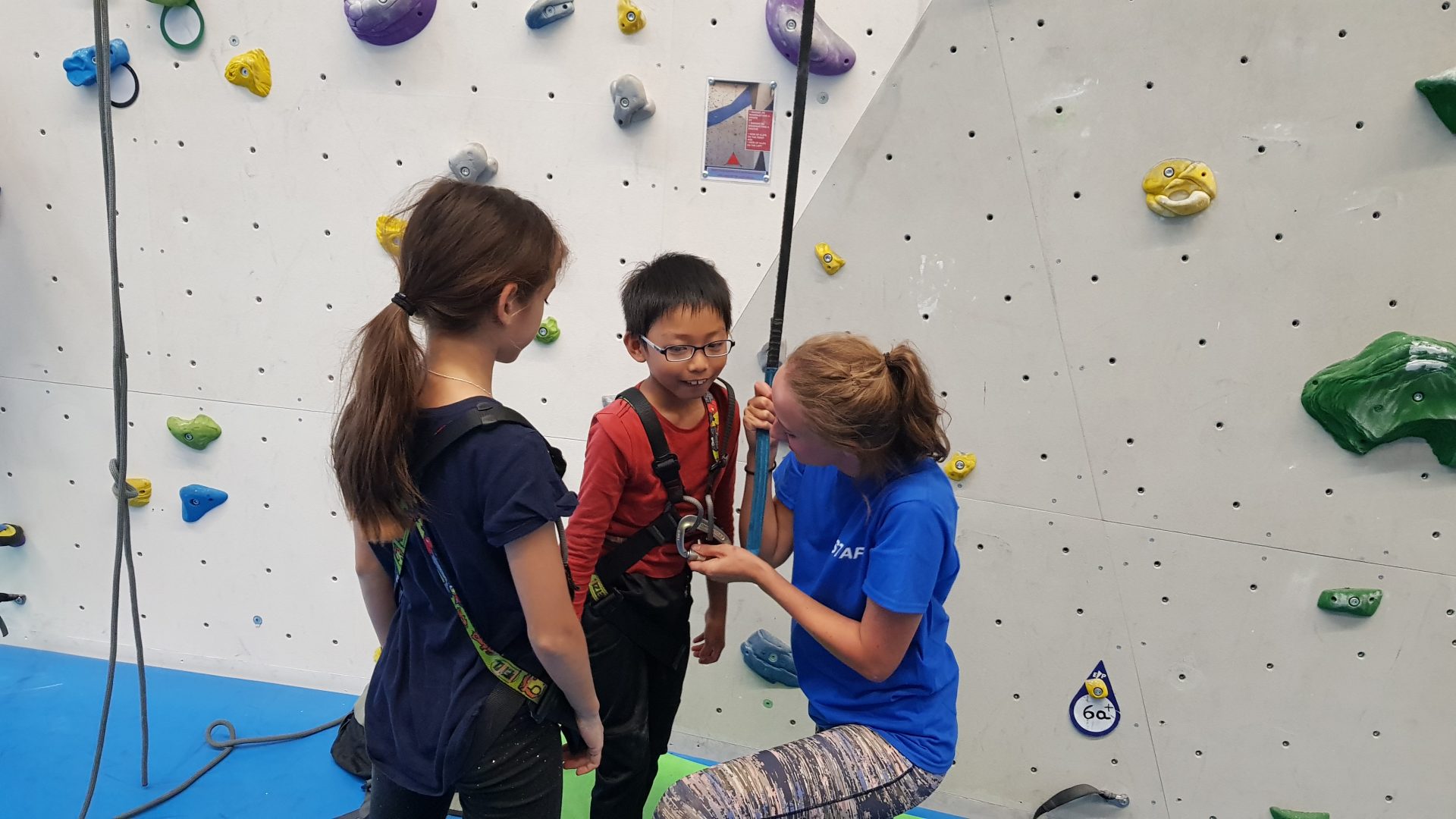 Altitude Camps Blog - two kids climbing with the assistance of an instructor