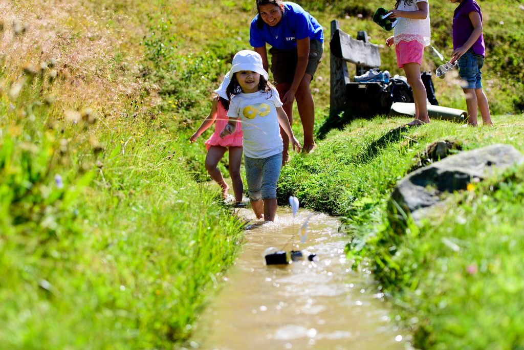 Day Camps in Switzerland - girl in river racing boat