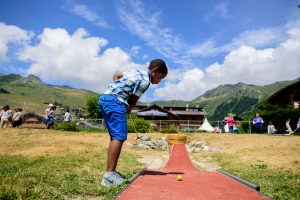 Sports camps - kid hitting a mini golf ball