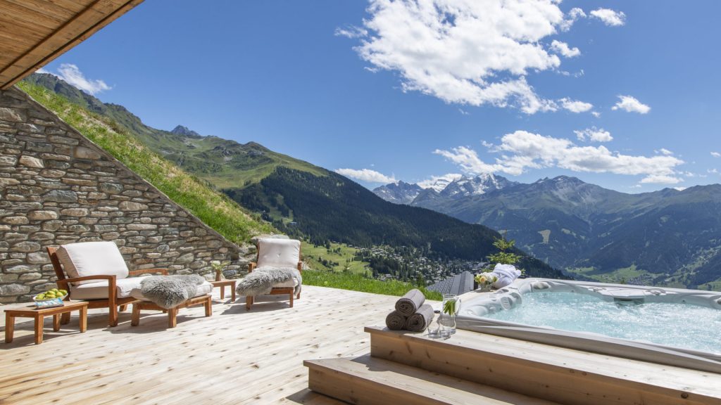 Outdoor jacuzzi overlooking Swiss mountain at luxury chalet