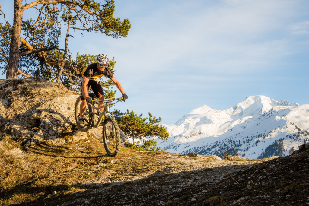 Mountain biker on ridge in with mountain in background, Verbier in Autumn