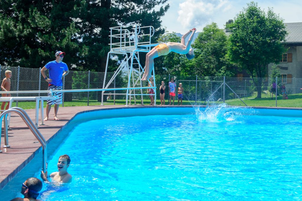 kids doing backflip off Verbier outdoor pool